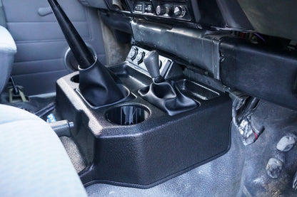 Close-up of a car's gear shift and console area with multiple gear positions.